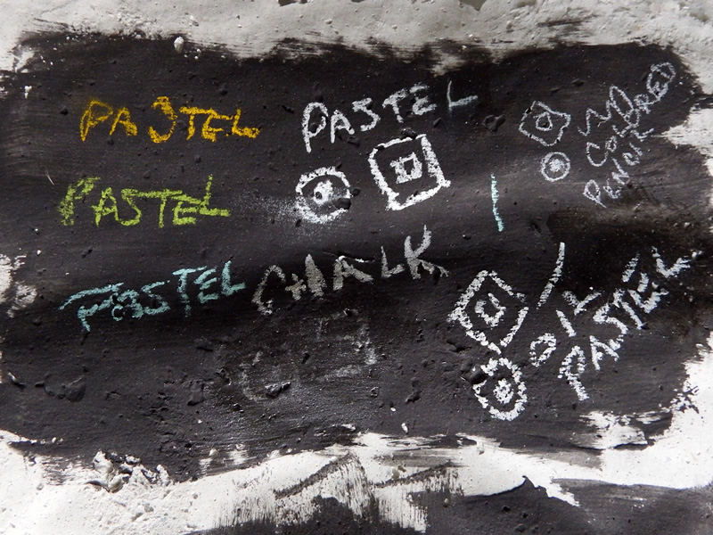 Test sheet for black papier maché smooth finish with pastels, colored pencil, oil pastel and chalk