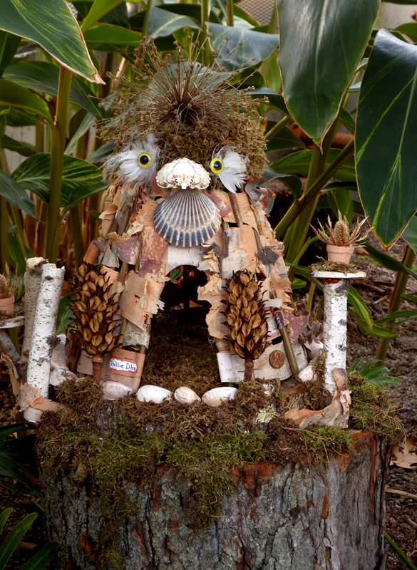 Fairy house made to look like an owl, with bark, feathers, moss and shells
